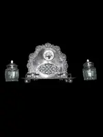 An inkwell made of embossed and openwork silver with stylized plant motifs and an enamel medallion.