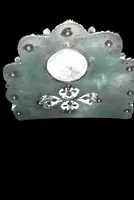 An inkwell made of embossed and openwork silver with stylized plant motifs and an enamel medallion.