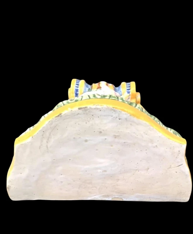 Majolica shelf featuring a neoclassical face and floral and geometric motifs in relief... Minardi