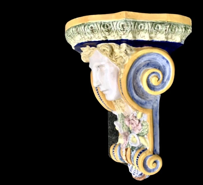 Majolica shelf featuring a neoclassical face and floral and geometric motifs in relief... Minardi