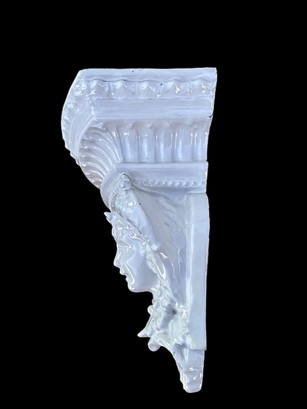 White majolica shelf featuring a female figure, dolphins, and geometric marine motifs. Faenza