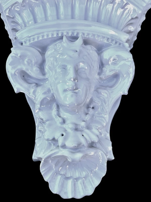 White majolica shelf featuring a female figure, dolphins, and geometric marine motifs. Faenza
