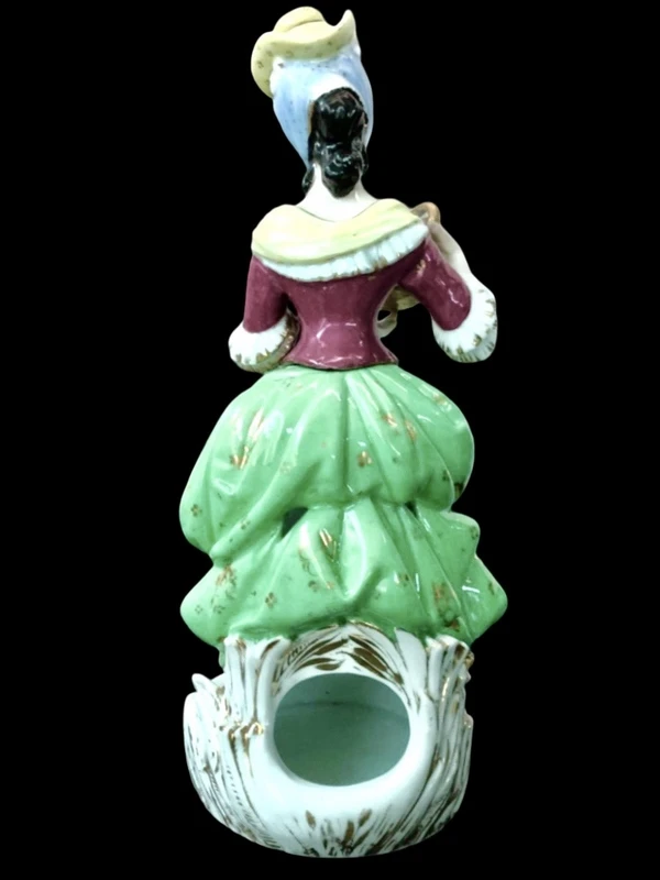 Polychrome porcelain tea pot nightlight depicting a lady with a watering can