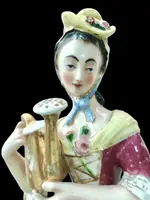 Polychrome porcelain tea pot nightlight depicting a lady with a watering can