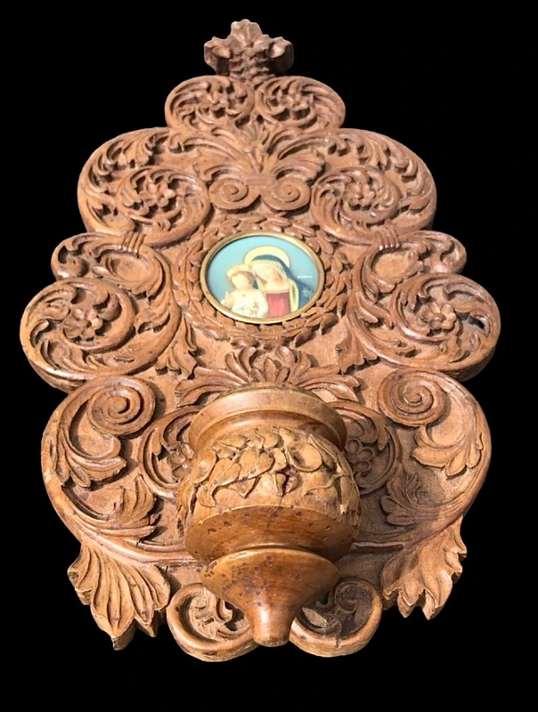 Acquasantiera in legno scolpito con motivi vegetali stilizzati e volute rocaille.