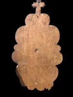Acquasantiera in legno scolpito con motivi vegetali stilizzati e volute rocaille.