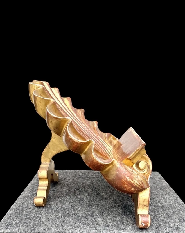 A shell-shaped lectern made of carved and gilded wood with rocaille motifs.