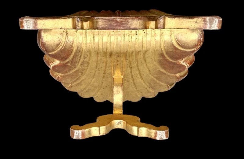 A shell-shaped lectern made of carved and gilded wood with rocaille motifs.