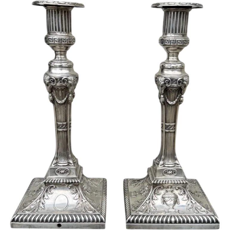 Coppia di candelieri in argento con decoro a motivi geometrici,teste di caproni,vasi,festoni