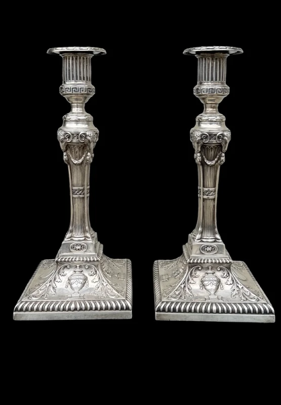 Coppia di candelieri in argento con decoro a motivi geometrici,teste di caproni,vasi,festoni