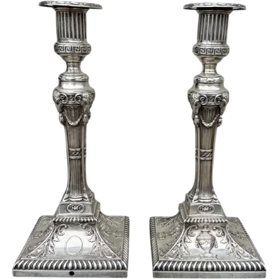 Pair of silver candlesticks decorated with geometric motifs, goat heads, vases, and festoons