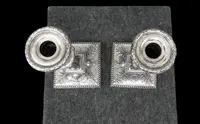 Coppia di candelieri in argento con decoro a motivi geometrici,teste di caproni,vasi,festoni