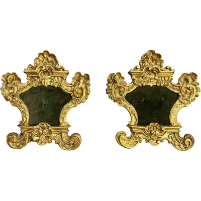 Pair of carved wooden cartoglories with gold leaf