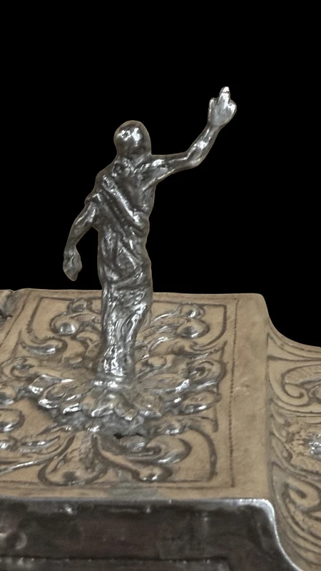 Cendrier en argent repoussé, orné de festons de feuilles et de volutes.