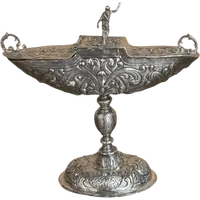 Cendrier en argent repoussé, orné de festons de feuilles et de volutes.