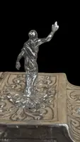 Cendrier en argent repoussé, orné de festons de feuilles et de volutes.