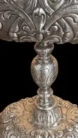 Cendrier en argent repoussé, orné de festons de feuilles et de volutes.