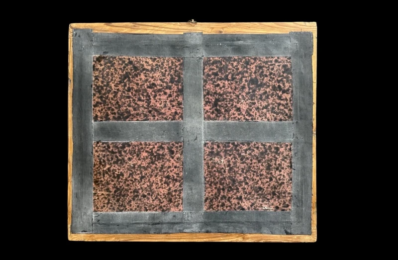 Quadro reliquiario con composizione in legno traforato in rilievo con putti e motivi vegetali.
