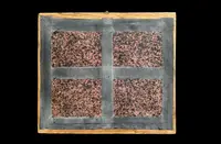 Quadro reliquiario con composizione in legno traforato in rilievo con putti e motivi vegetali.