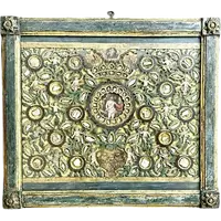 Quadro reliquiario con composizione in legno traforato in rilievo con putti e motivi vegetali.