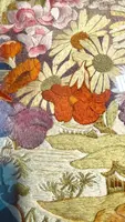 Framed panel featuring a vase of flowers embroidered on fabric.