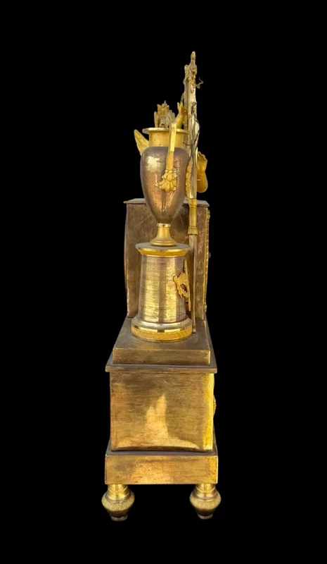 A clock made of mercury-gilded bronze depicting Cupid playing the lyre.