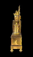 A clock made of mercury-gilded bronze depicting Cupid playing the lyre.