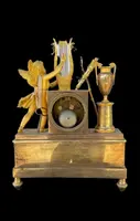 A clock made of mercury-gilded bronze depicting Cupid playing the lyre.