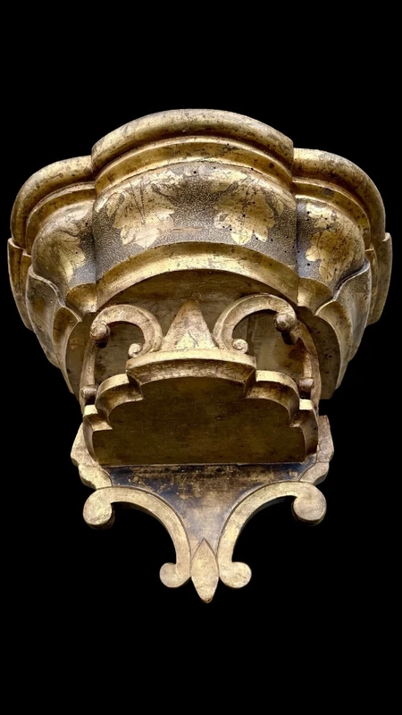 Carved wooden wall-mounted shelf with Mecca gilding and a marble top,