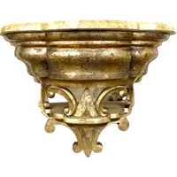 Carved wooden wall-mounted shelf with Mecca gilding and a marble top,