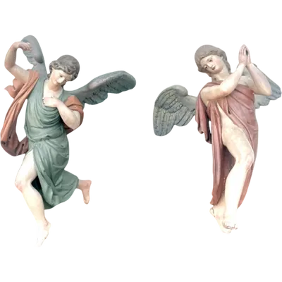 A pair of full-length polychrome angels carved from wood and painted.