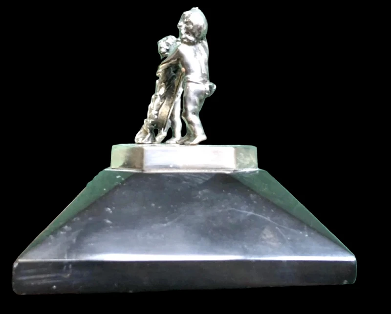Solid silver paperweight featuring two cherubs holding up a portrait frame