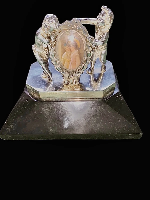 Solid silver paperweight featuring two cherubs holding up a portrait frame