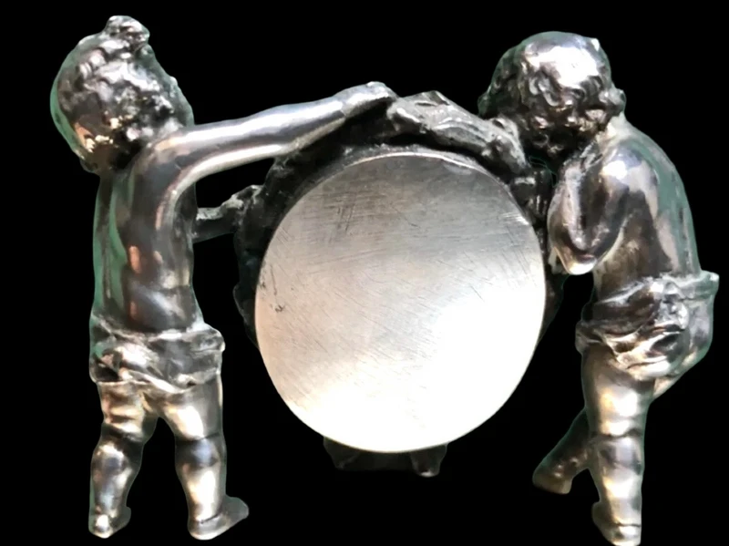 Solid silver paperweight featuring two cherubs holding up a portrait frame