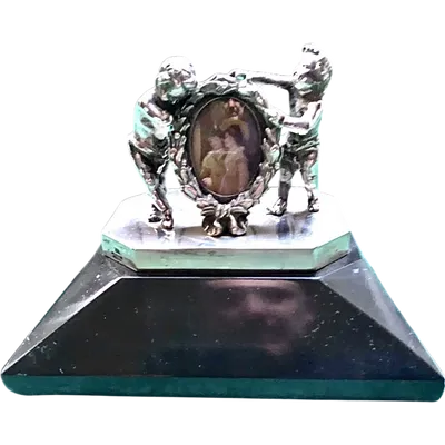 Solid silver paperweight featuring two cherubs holding up a portrait frame