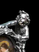 Solid silver paperweight featuring two cherubs holding up a portrait frame