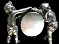 Solid silver paperweight featuring two cherubs holding up a portrait frame