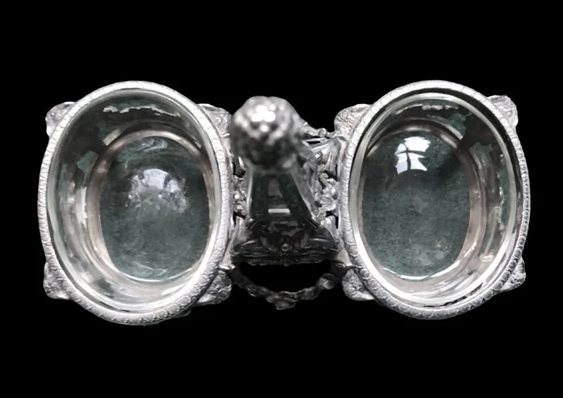 Double salt shaker set made of solid silver with glass compartments.