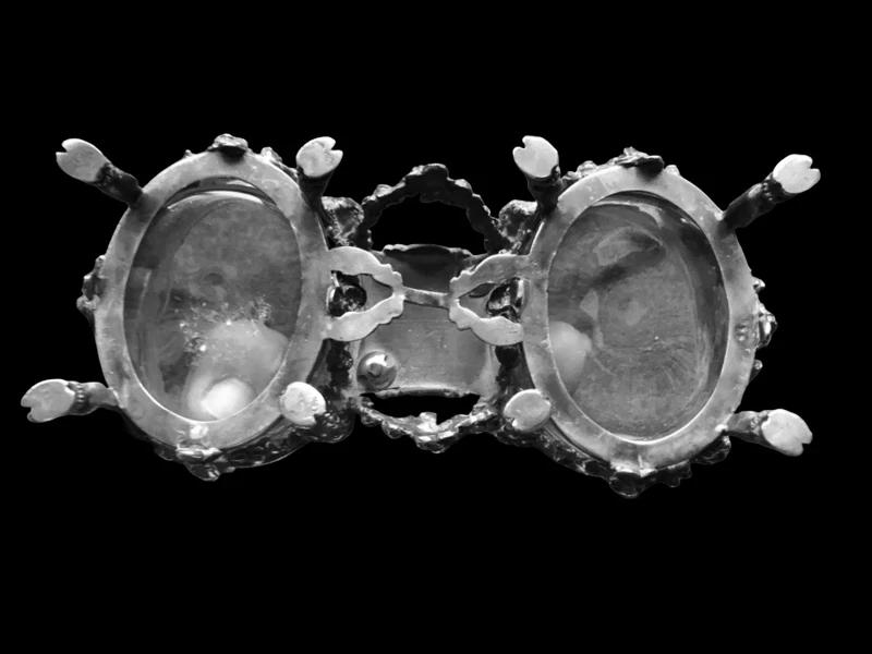 Double salt shaker set made of solid silver with glass compartments.