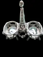 Double salt shaker set made of solid silver with glass compartments.