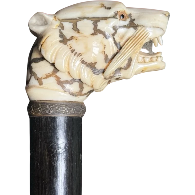 A walking stick with an ivory knob shaped like a tiger's head.