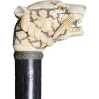 A walking stick with an ivory knob shaped like a tiger's head.