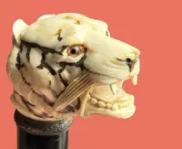 A walking stick with an ivory knob shaped like a tiger's head.