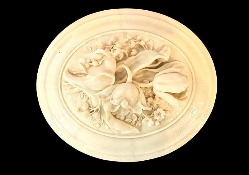 Boîte ovale en ivoire, ornée de motifs végétaux et floraux en bas-relief.