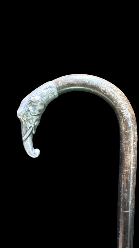 A walking stick with a silver knob shaped like an elephant's head.