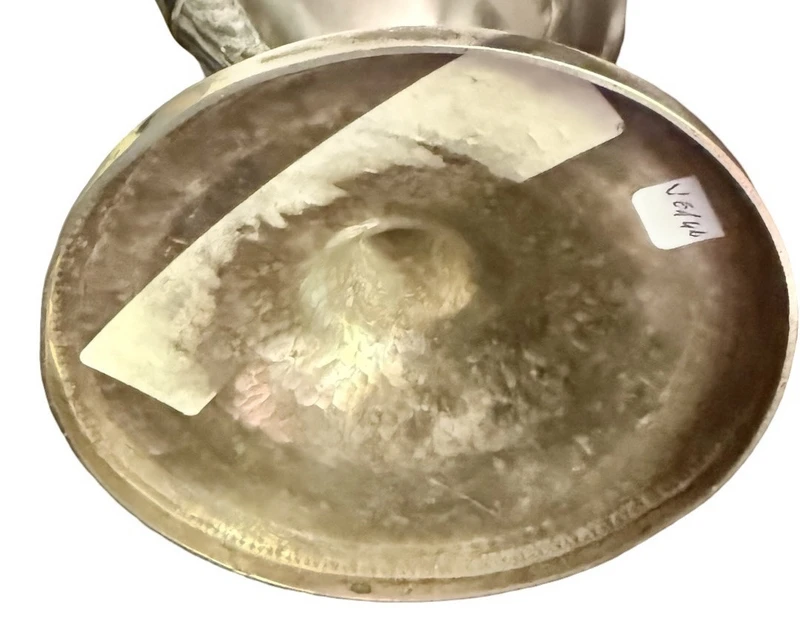 A silver coffee pot with a pear-shaped body on a circular base adorned with lanceolate leaves.