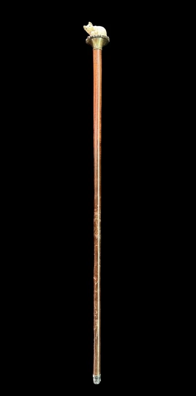 Walking stick with a deer antler knob depicting a cat playing with a ball of yarn.
