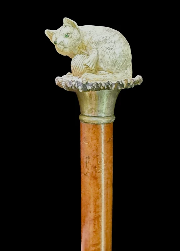 Walking stick with a deer antler knob depicting a cat playing with a ball of yarn.