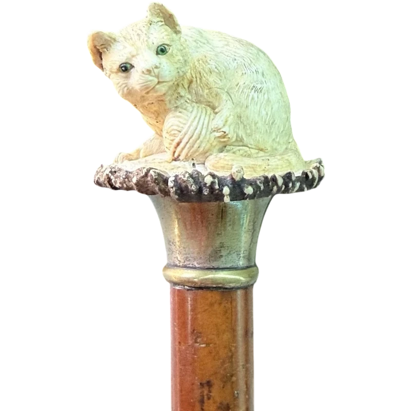 Walking stick with a deer antler knob depicting a cat playing with a ball of yarn.
