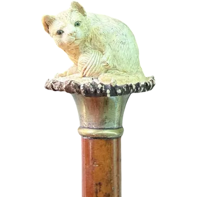 Walking stick with a deer antler knob depicting a cat playing with a ball of yarn.
